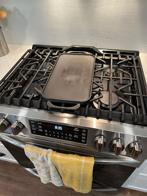 Bright kitchen with gas range, hood vent, and bar seating
